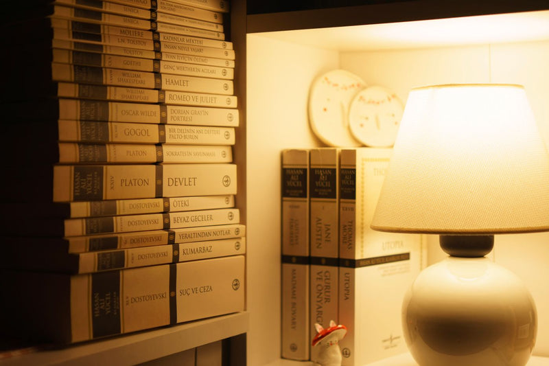 Soft amber lamp lighting a bookshelf — room inspiration, not a WARMELO product